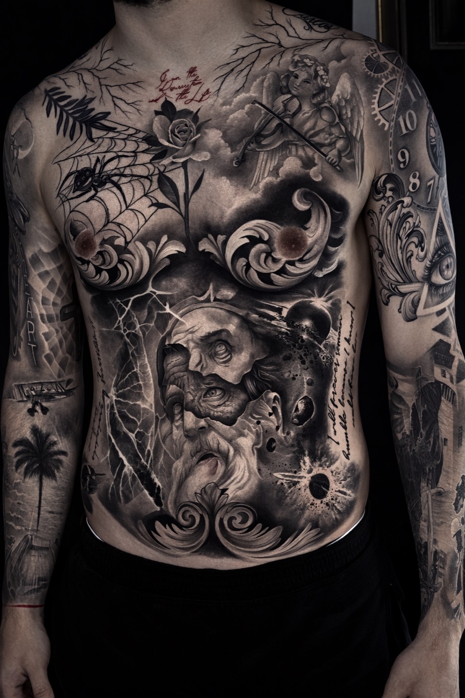 Black and grey torso tattoo featuring a bearded face, clouds, lightning and ornamental scrollwork